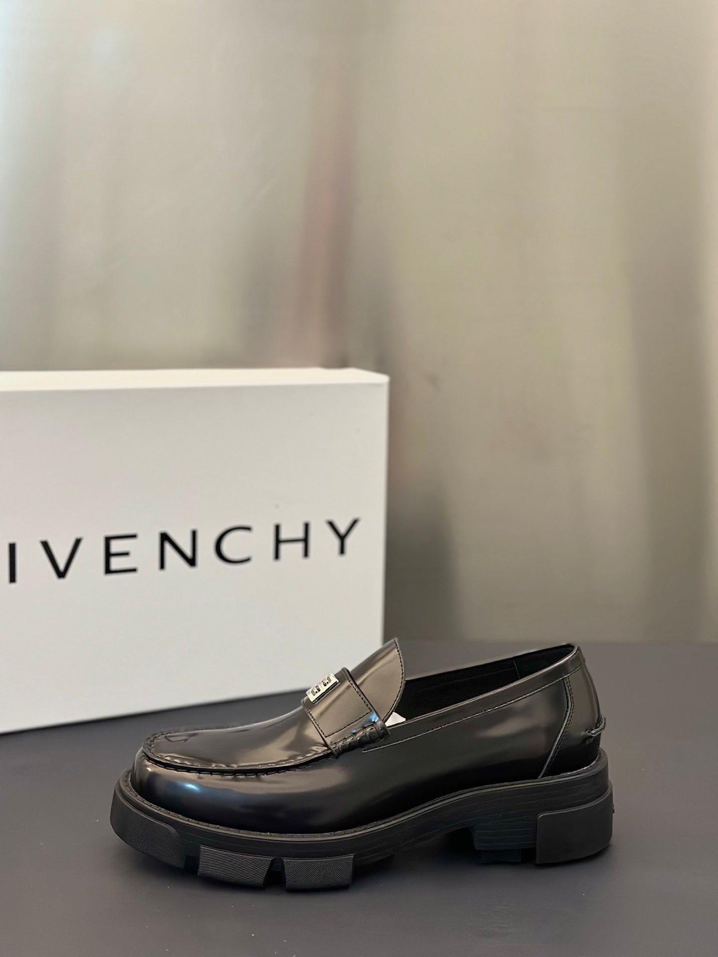 Black leather loafer with silver logo buckle and rounded toe