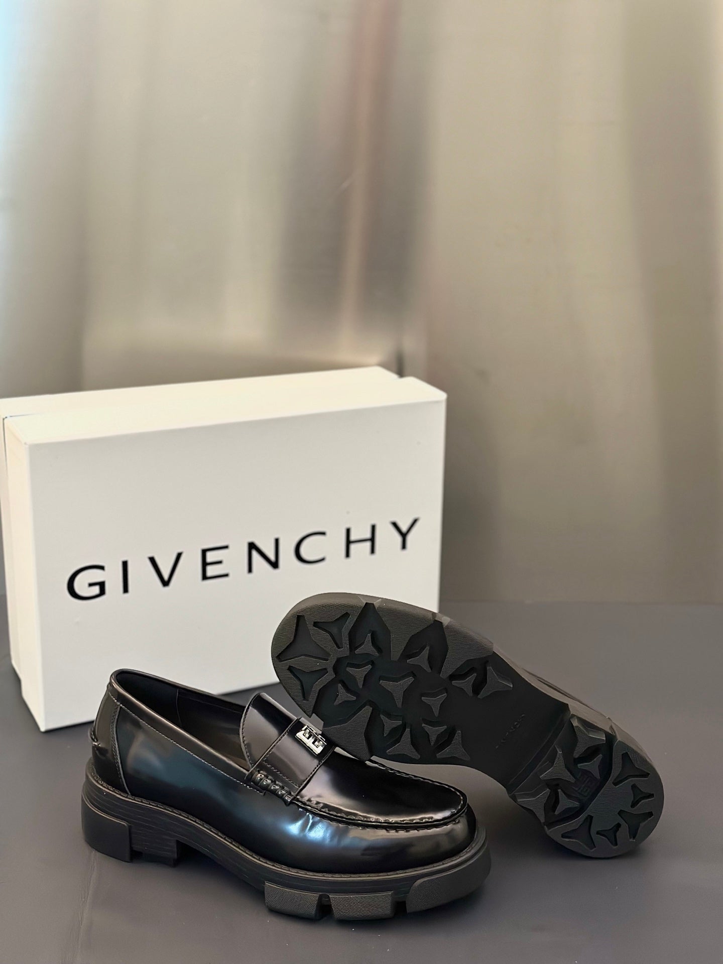 Black leather loafers with logo buckle and textured star-pattern sole