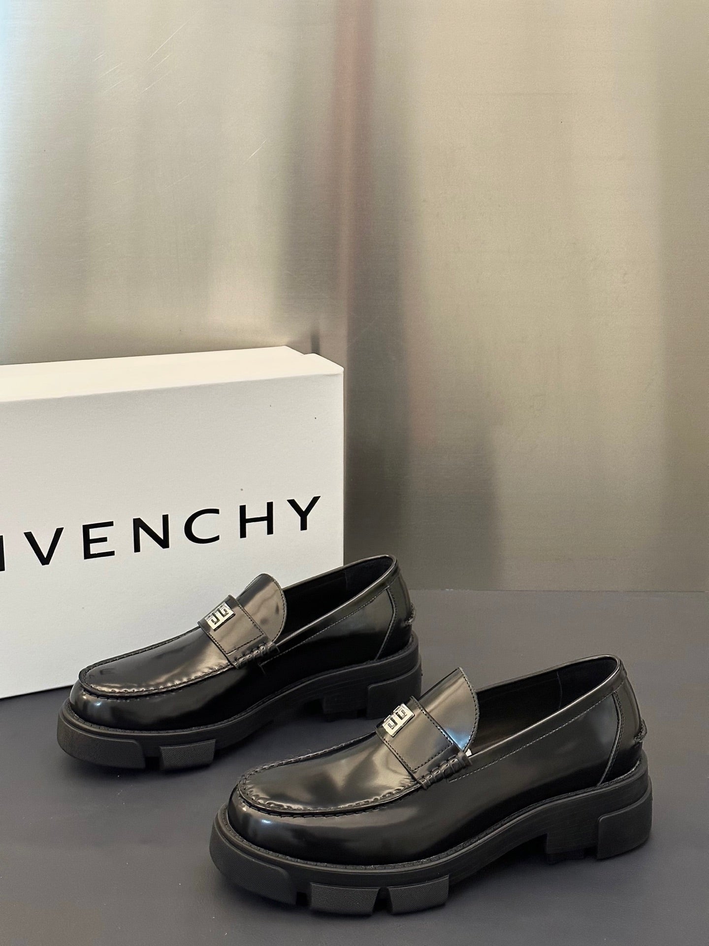 Black leather loafers with silver logo buckle and chunky platform sole