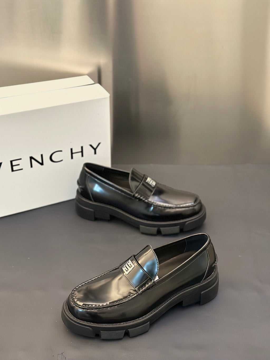 Black leather loafers with silver logo buckle, low block sole