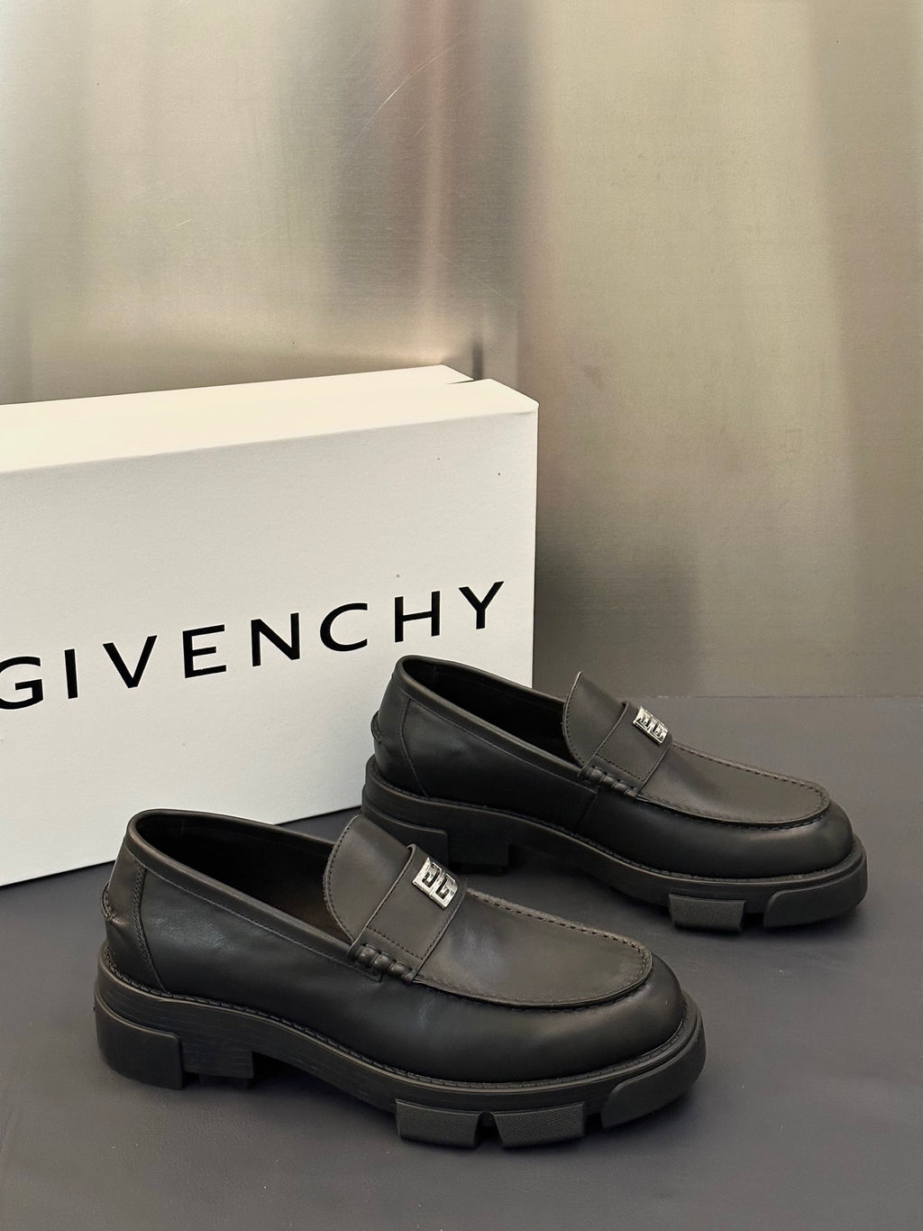 Pair of dark leather loafers with square logo buckle strap, thick platform sole