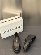 Dark leather loafers with square logo buckle and rounded moc-toe, chunky tread sole