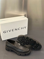 Dark leather loafer with square logo buckle and textured star-pattern outsole