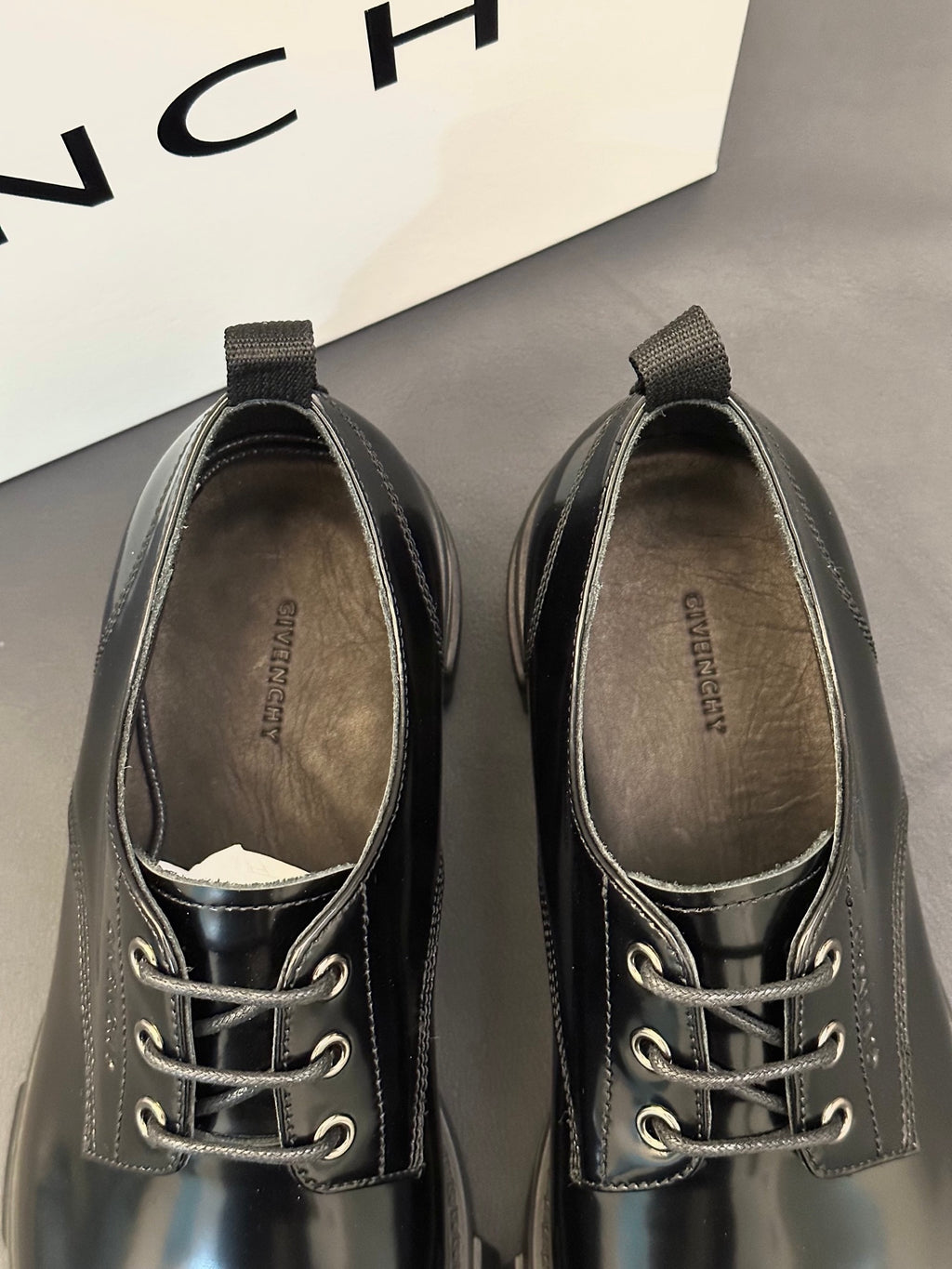 Black leather lace-up shoes with metal eyelets and textured collar lining