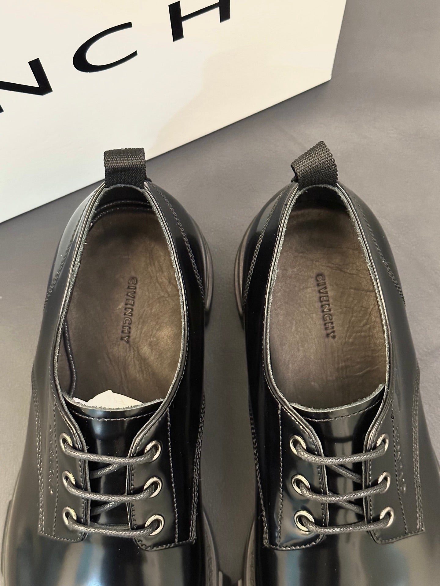 Black leather lace-up shoes with metal eyelets and textured collar lining