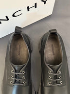 Dark leather lace-up shoes, top view with laces and eyelets.