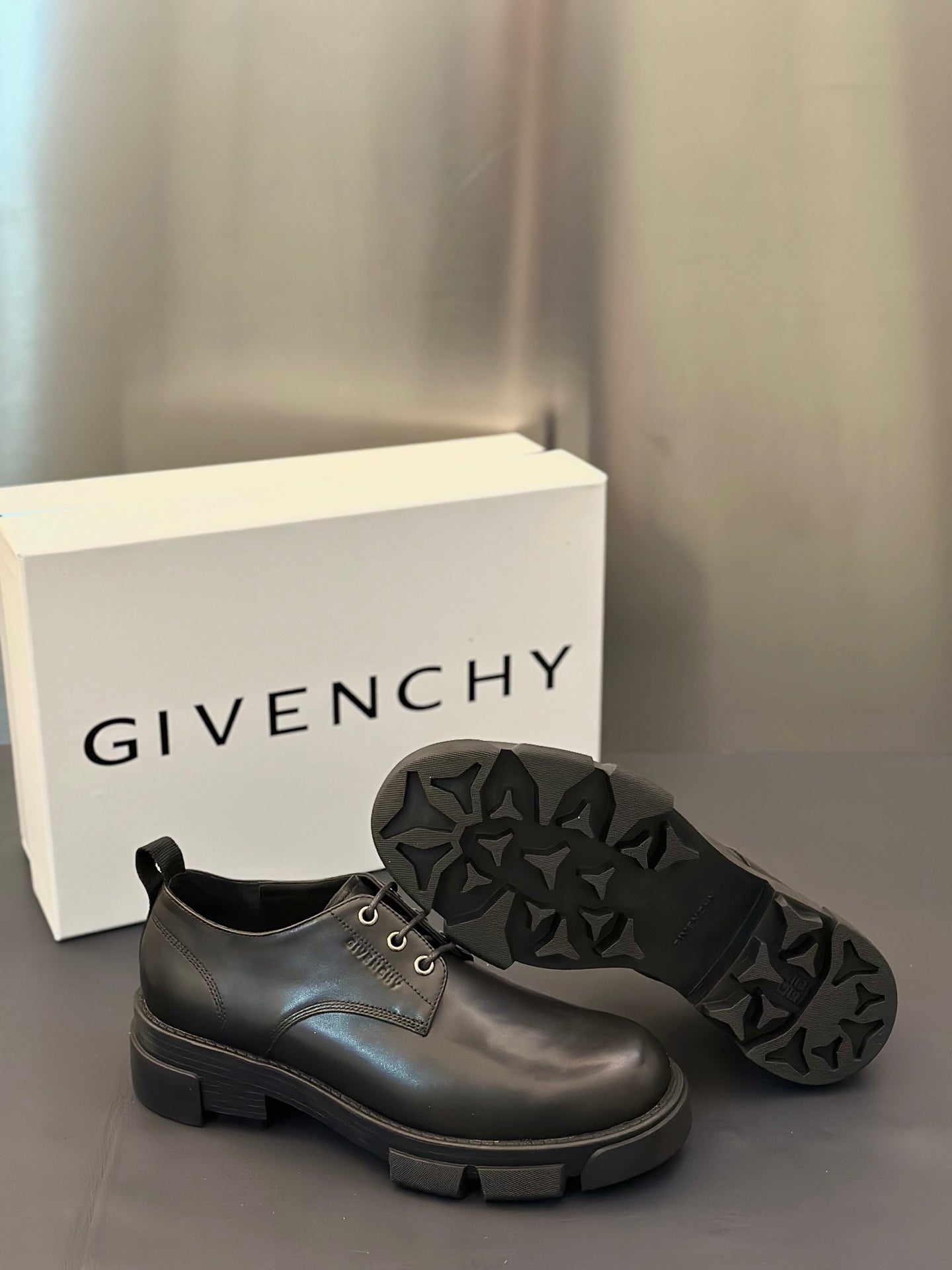 Black leather lace-up shoes with star-textured rubber outsole and chunky sole