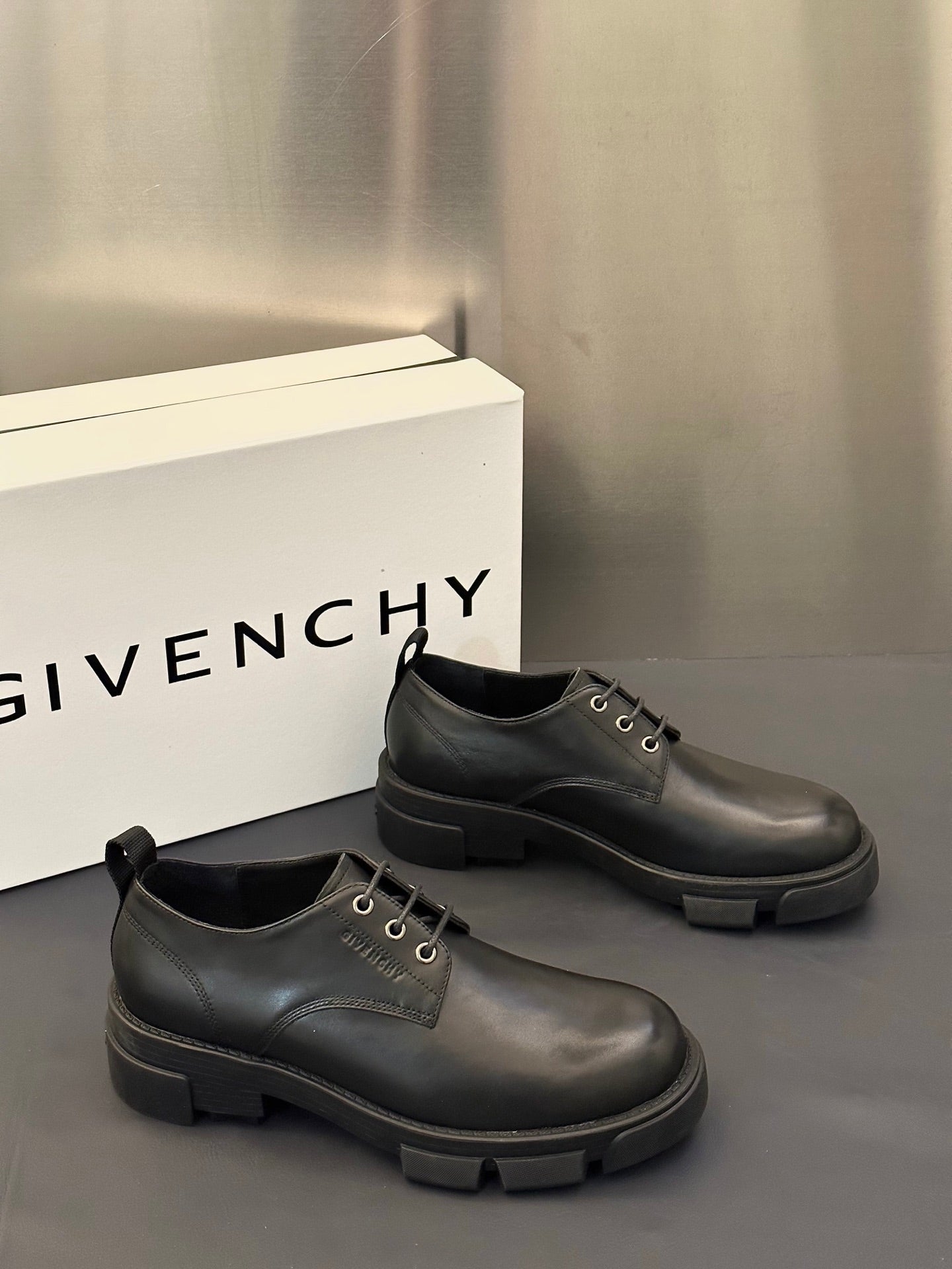 Dark leather lace-up shoes with thick rubber sole, side-by-side pair.