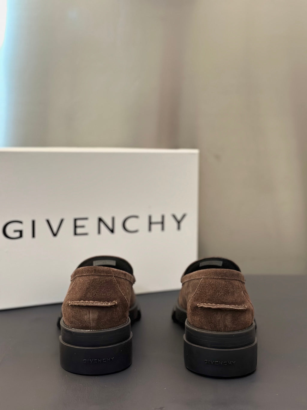 Brown suede loafers, rear view, with dark rubber sole and low heel