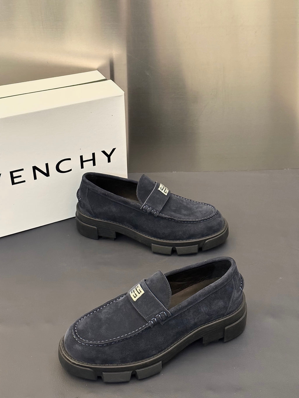 Givenchy suede loafers, dark navy, side profile with metal logo plate and tread sole