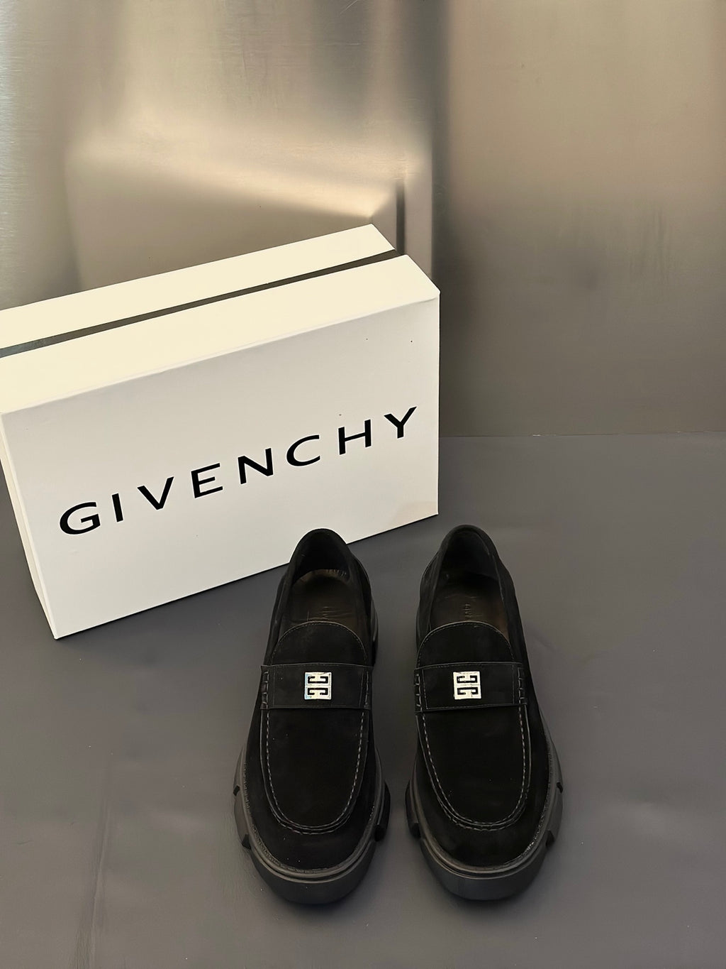 Black suede loafers with square logo buckle and cushioned lug sole, pair view