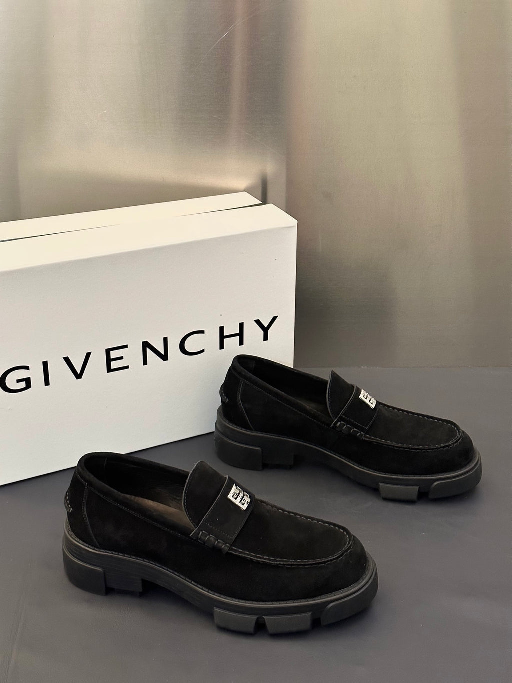 Black slip-on loafers with front strap detail and chunky lug sole, side angle