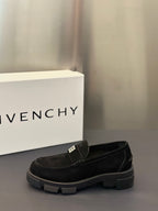 Black slip-on loafers with logo strap detail and chunky rubber sole, side view