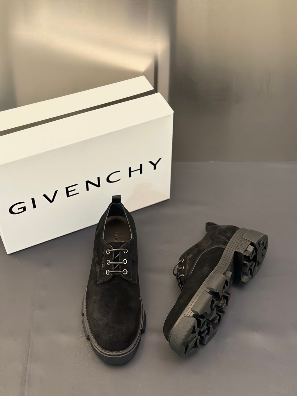 Black lace-up shoes with low heel, metal eyelets, and side profile detailing.