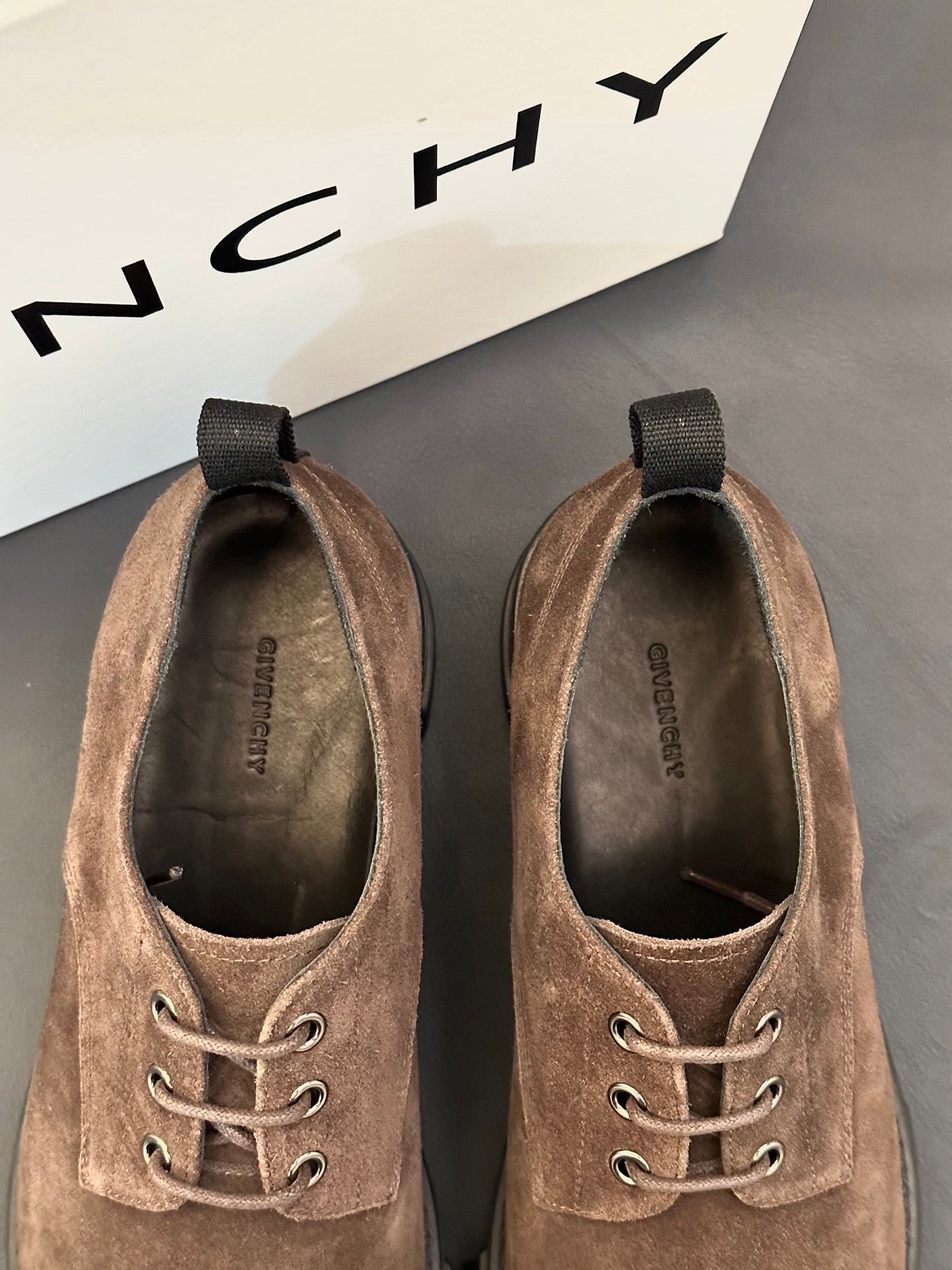 Brown suede lace-up shoes with metal eyelets and dark rubber sole