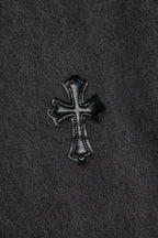 Black cross appliqué patch on dark gray denim fabric