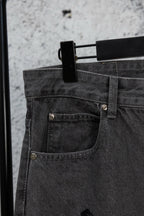 Dark denim pants with buttoned front pocket and rivet details