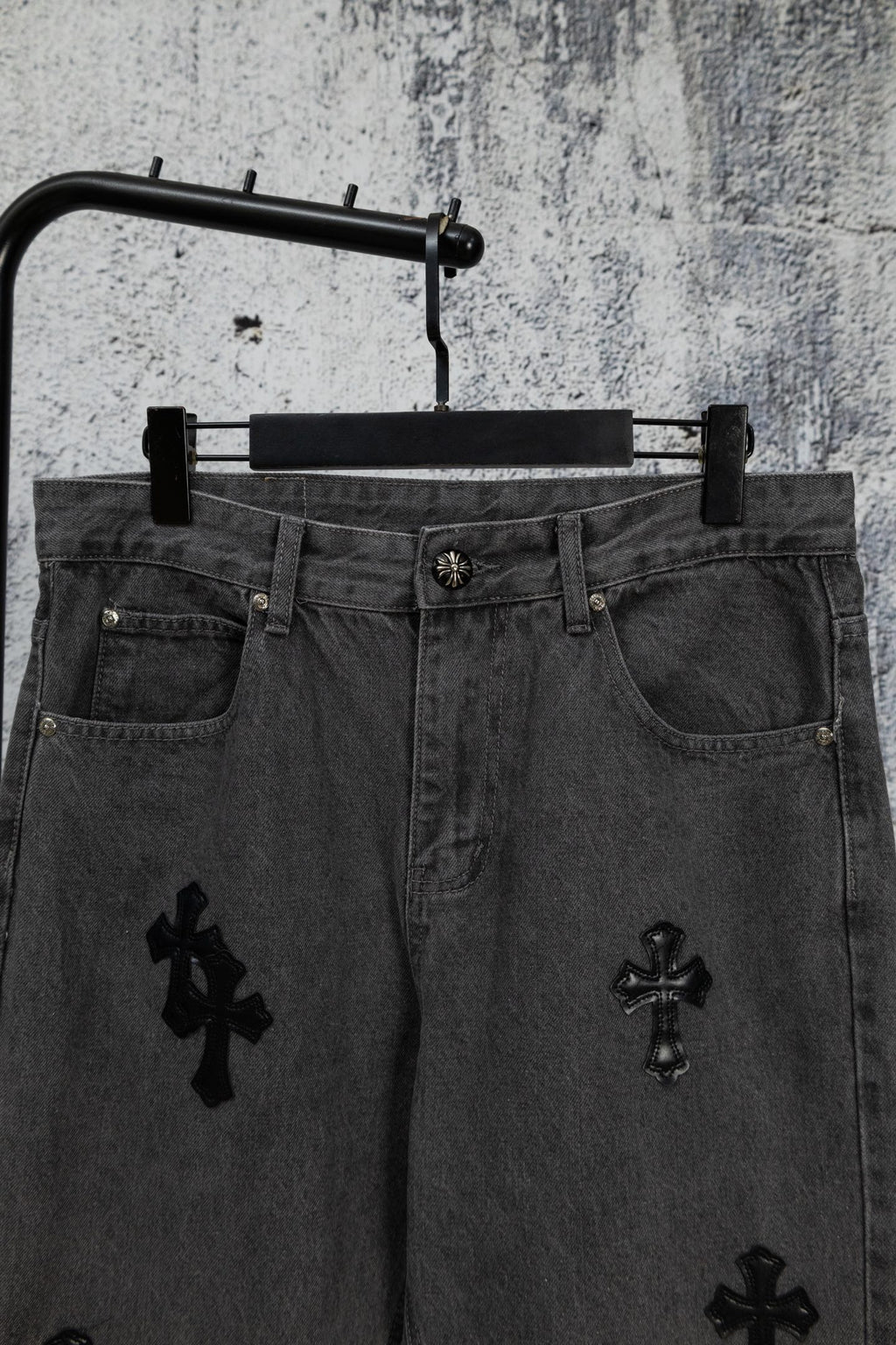 Dark denim pants with cross embroidery on front and button waistband