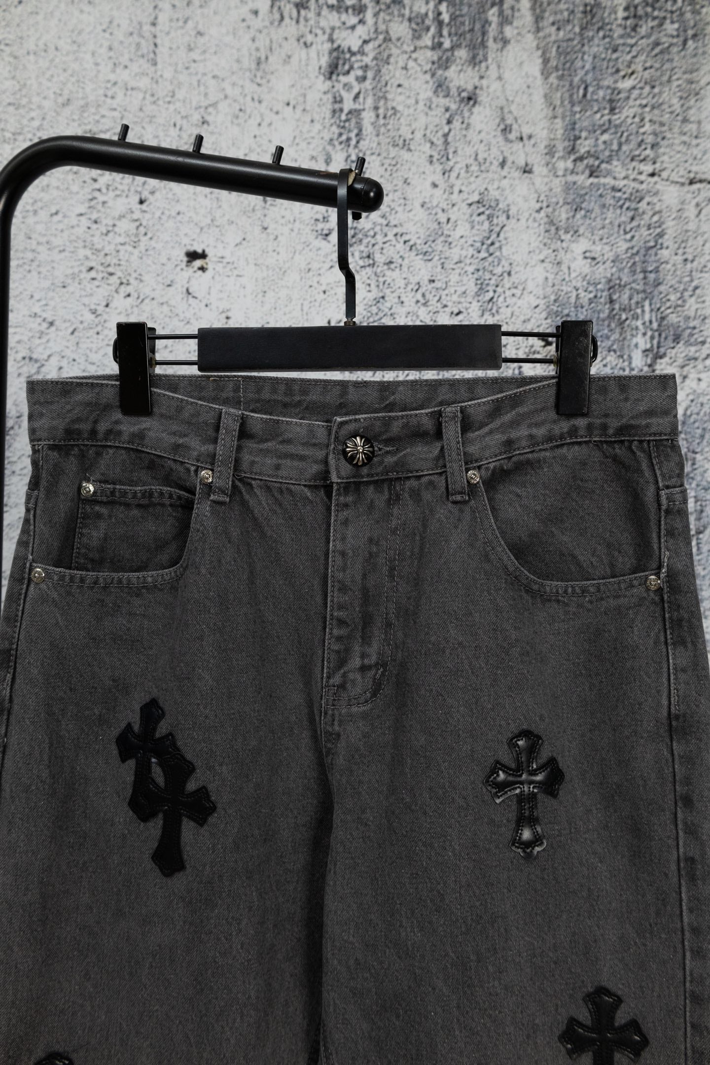 Dark denim pants with cross embroidery on front and button waistband