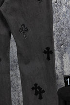 Dark gray denim pants leg with small black cross appliques at staggered spots