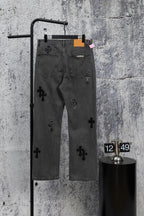 Dark gray denim pants with scattered black cross appliques and belt loops