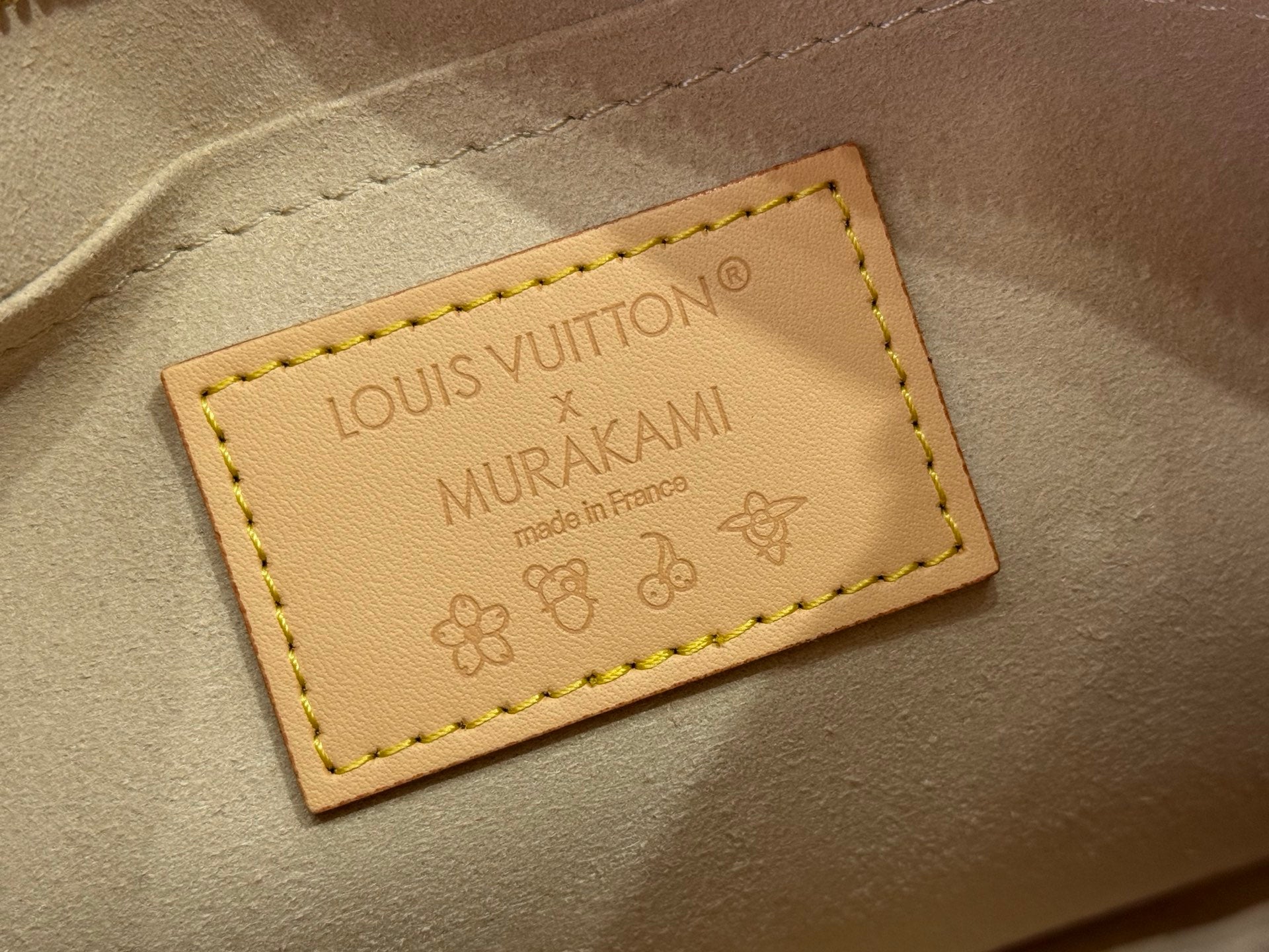 Louis Vuitton leather brand label patch with embossed text and stitched border