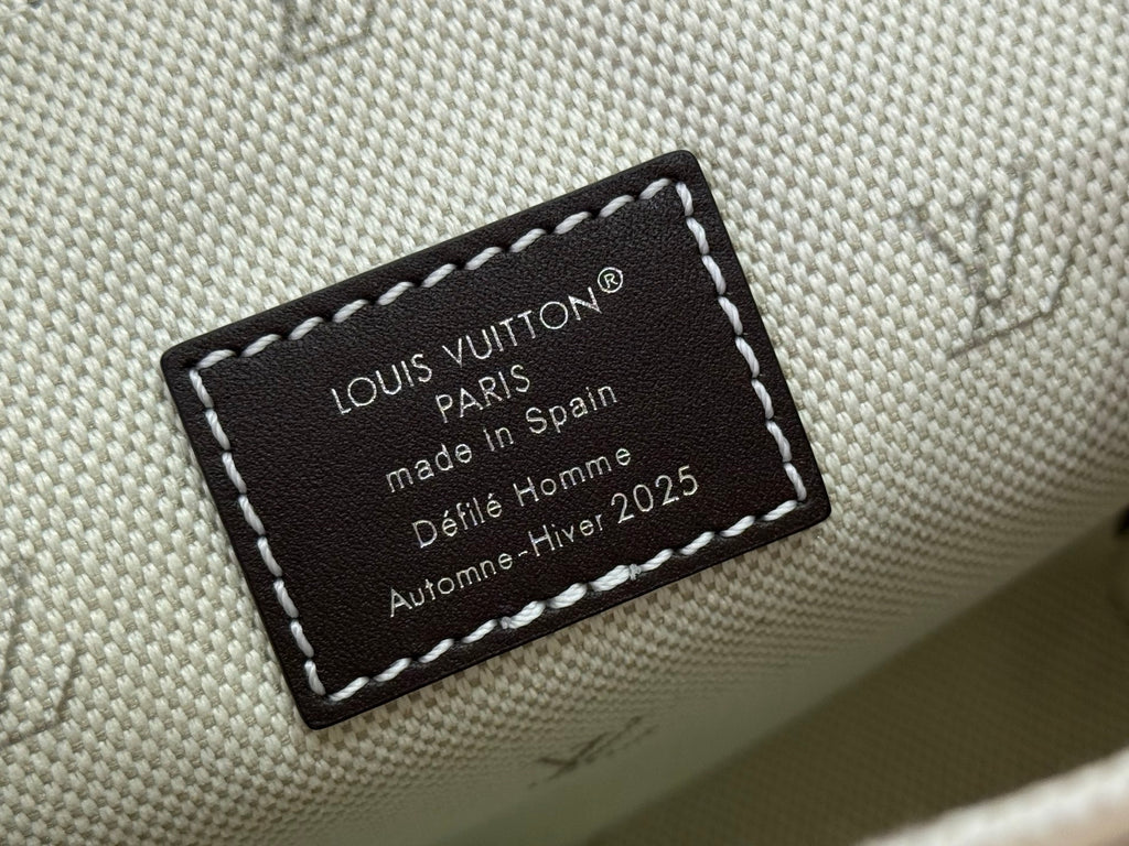 Canvas label stitched to cream fabric reading Louis Vuitton Paris and made in Spain