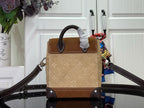 Tan mini backpack with embossed monogram pattern, dark handle, and shoulder straps