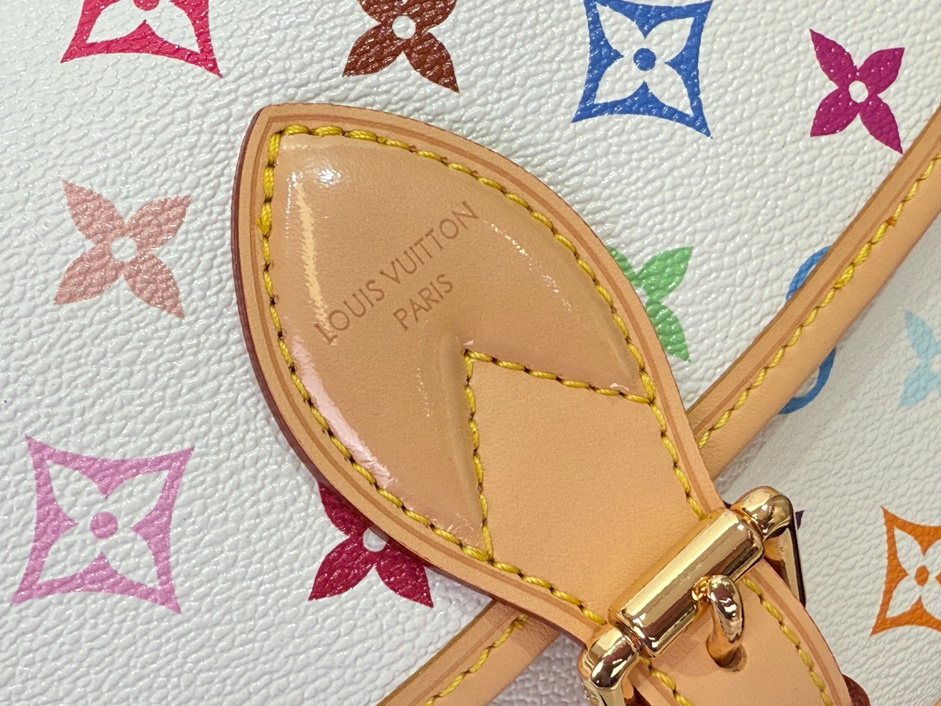 Louis Vuitton leather strap end with stamped logo and gold-tone hardware, multicolor trim