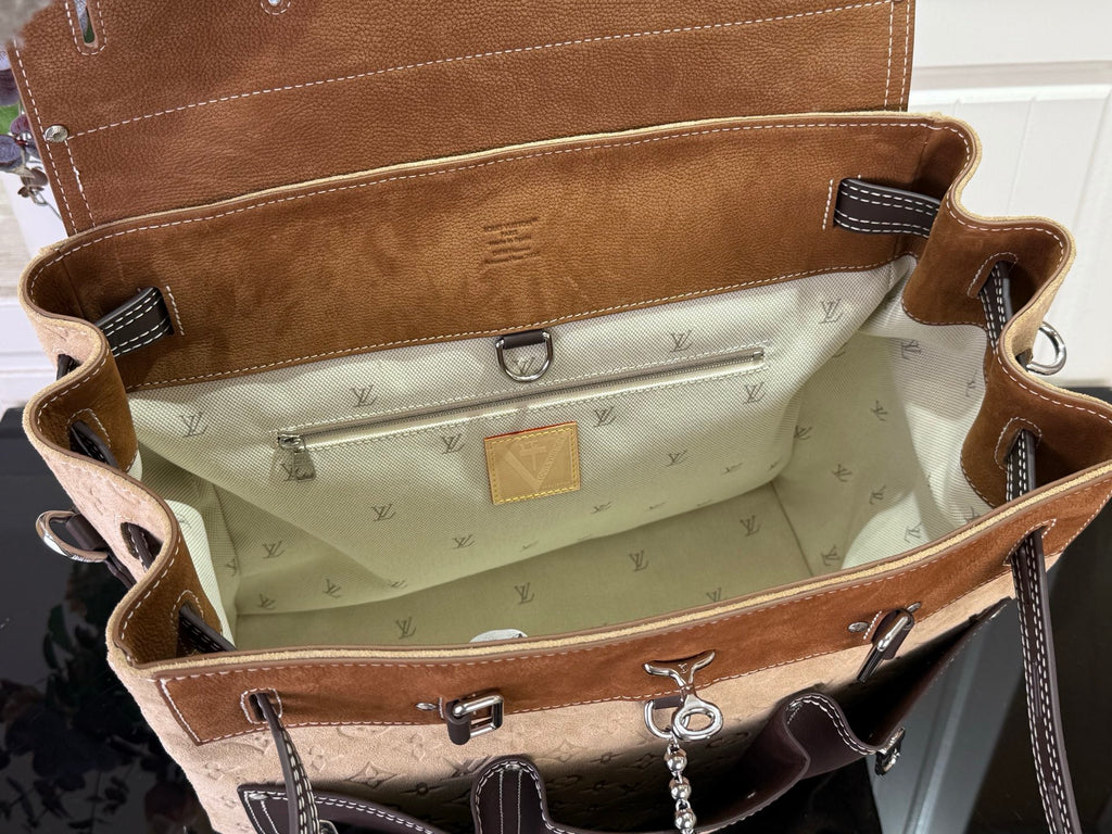 Handbag interior with tan monogram lining, zip pocket, hanging clasp and strap hooks
