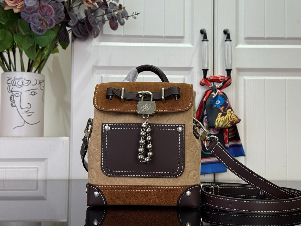 Brown mini leather backpack with top handle, flap front, and dark shoulder strap