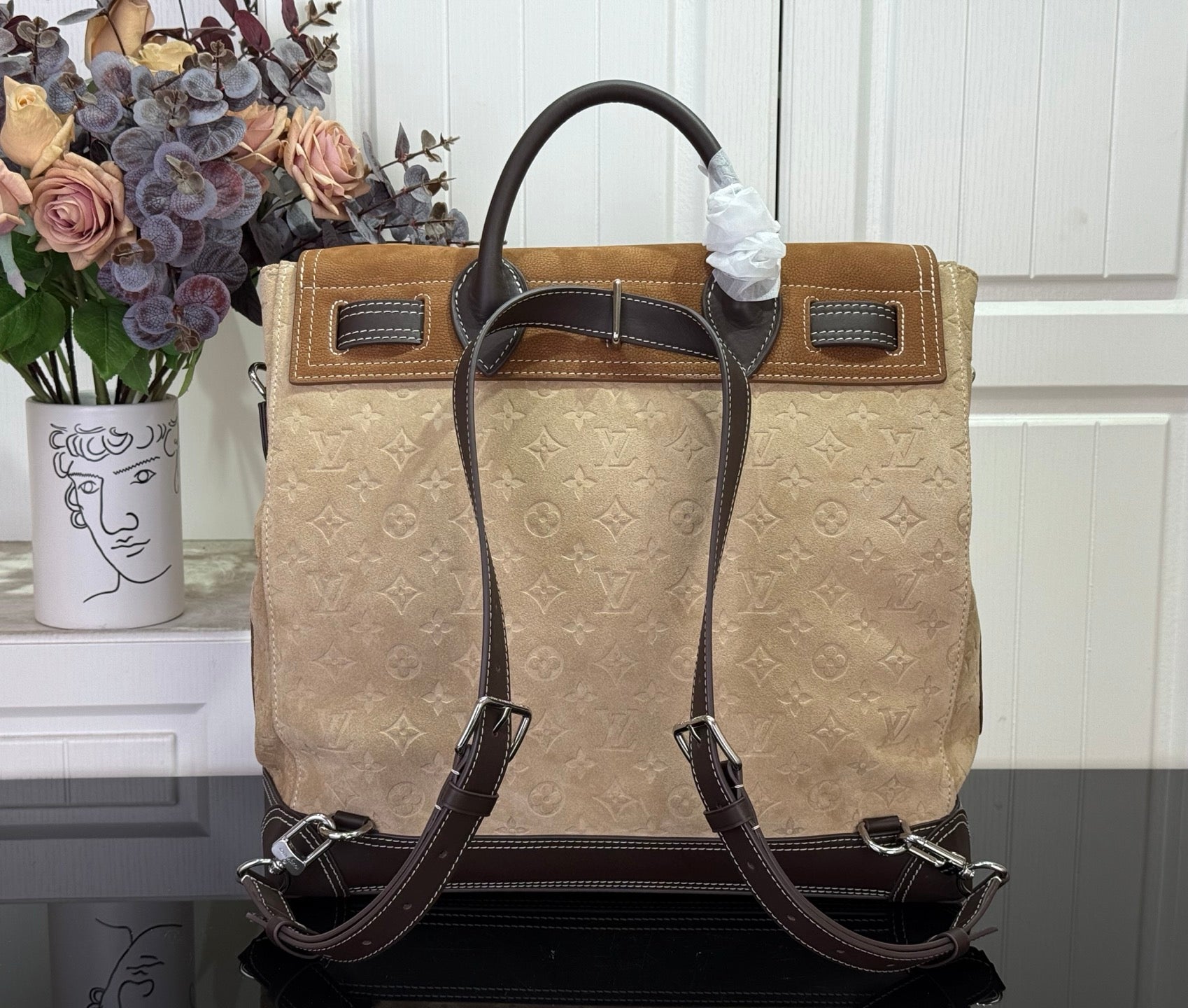 Louis Vuitton monogram tote handbag with top handles and dark leather straps, tan.