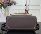 Louis Vuitton handbag back view with dark top panel and corner stitching, brown.