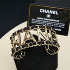 Gold-tone chain bracelet with black enamel links and CHANEL letter centerpiece