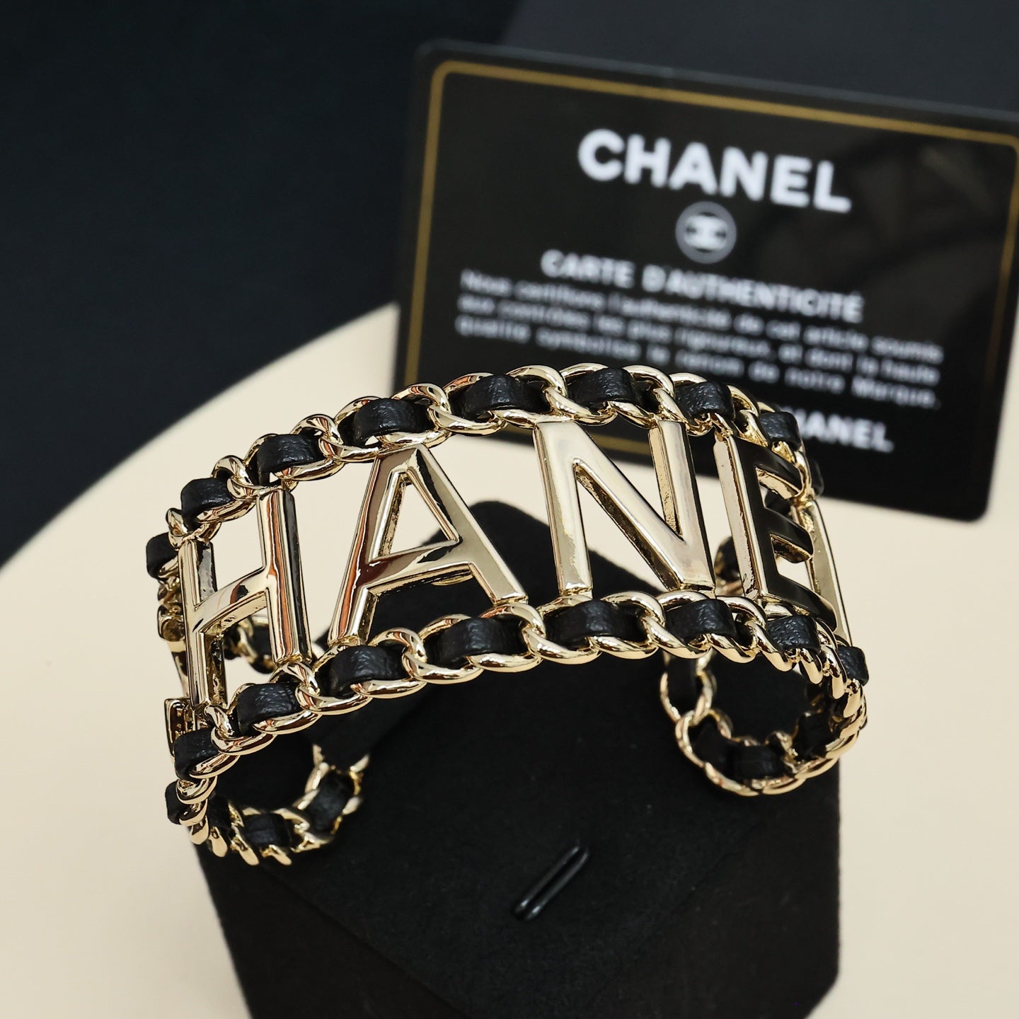 Gold-tone chain bracelet with black enamel links and CHANEL letter centerpiece