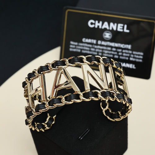 Gold-tone chain bracelet with black enamel links and CHANEL letter centerpiece