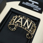 Gold-tone chain bracelet with CHANEL letter centerpiece and black enamel link borders