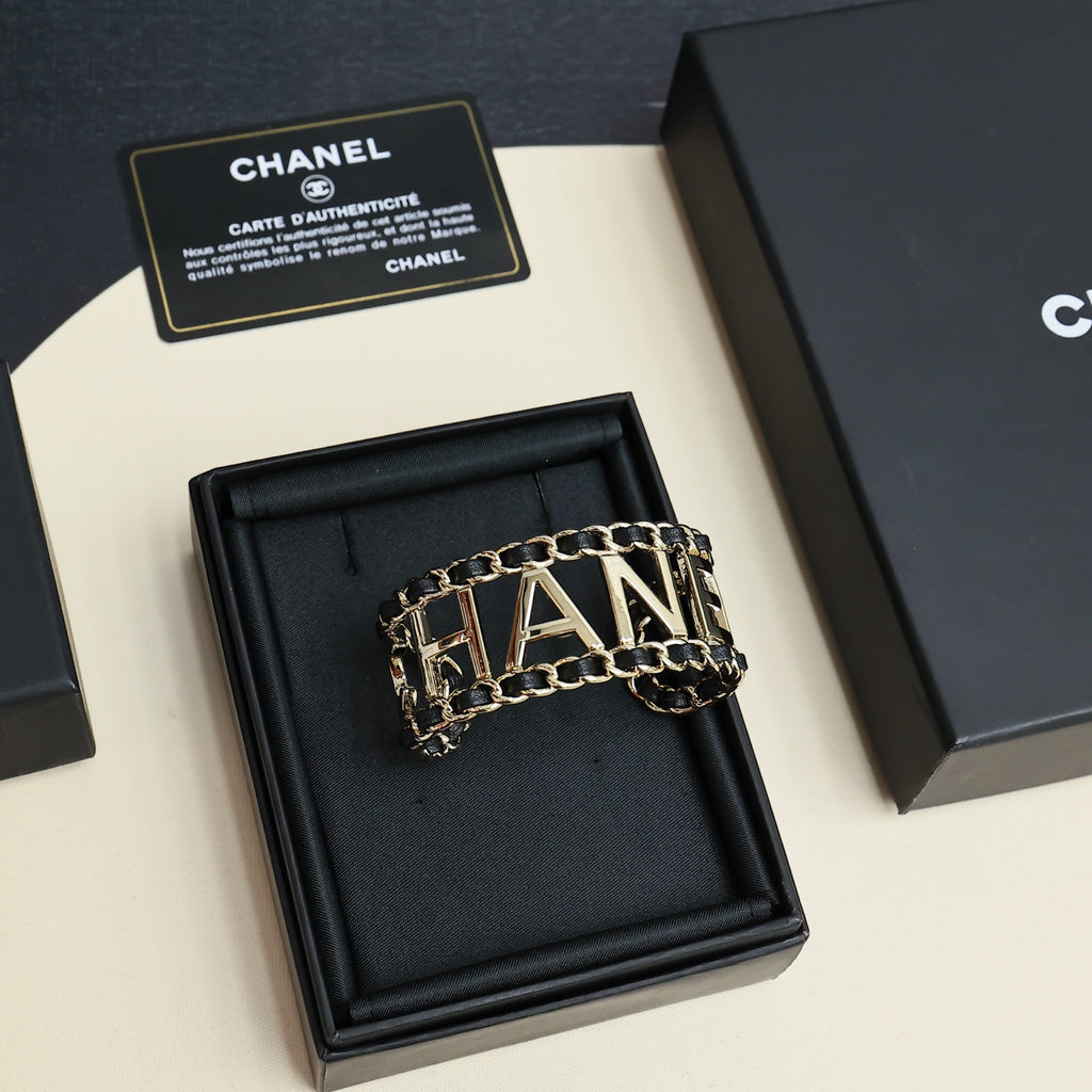 Gold-tone CHANEL letter chain bracelet in a black display box