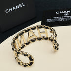 Gold-tone chain bracelet with CHANEL letter links and black enamel detail