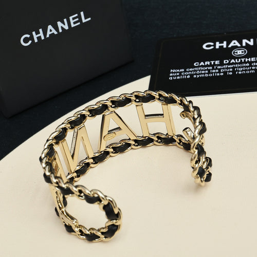 Gold-tone chain bracelet with CHANEL letter links and black enamel detail