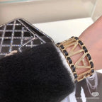 Gold-tone chain bracelet with CHANEL letter links and black enamel on wrist