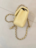 Chanel quilted mini shoulder bag with gold chain strap, side view and clasp