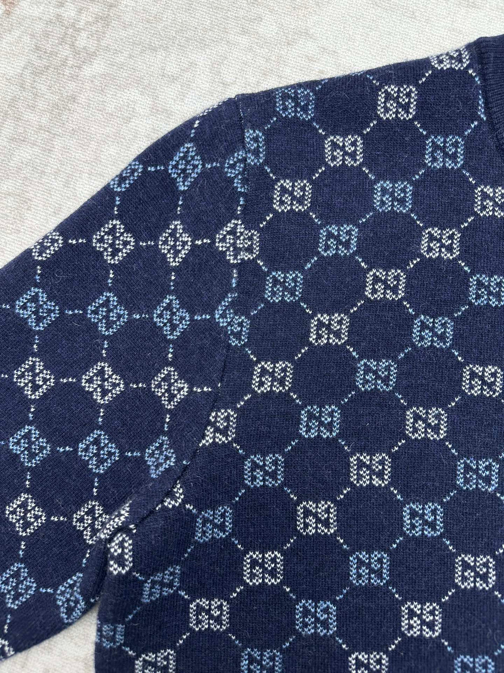 Navy long-sleeve sweater with allover GG monogram knit pattern on the sleeve