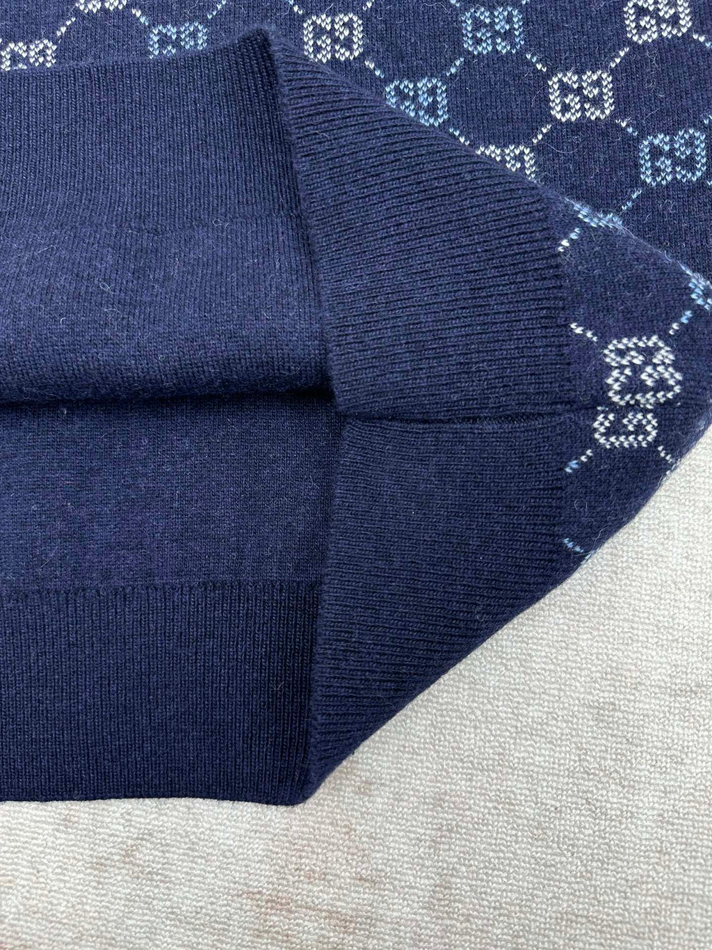Navy knit sweater sleeve cuff with GG monogram pattern and ribbed trim