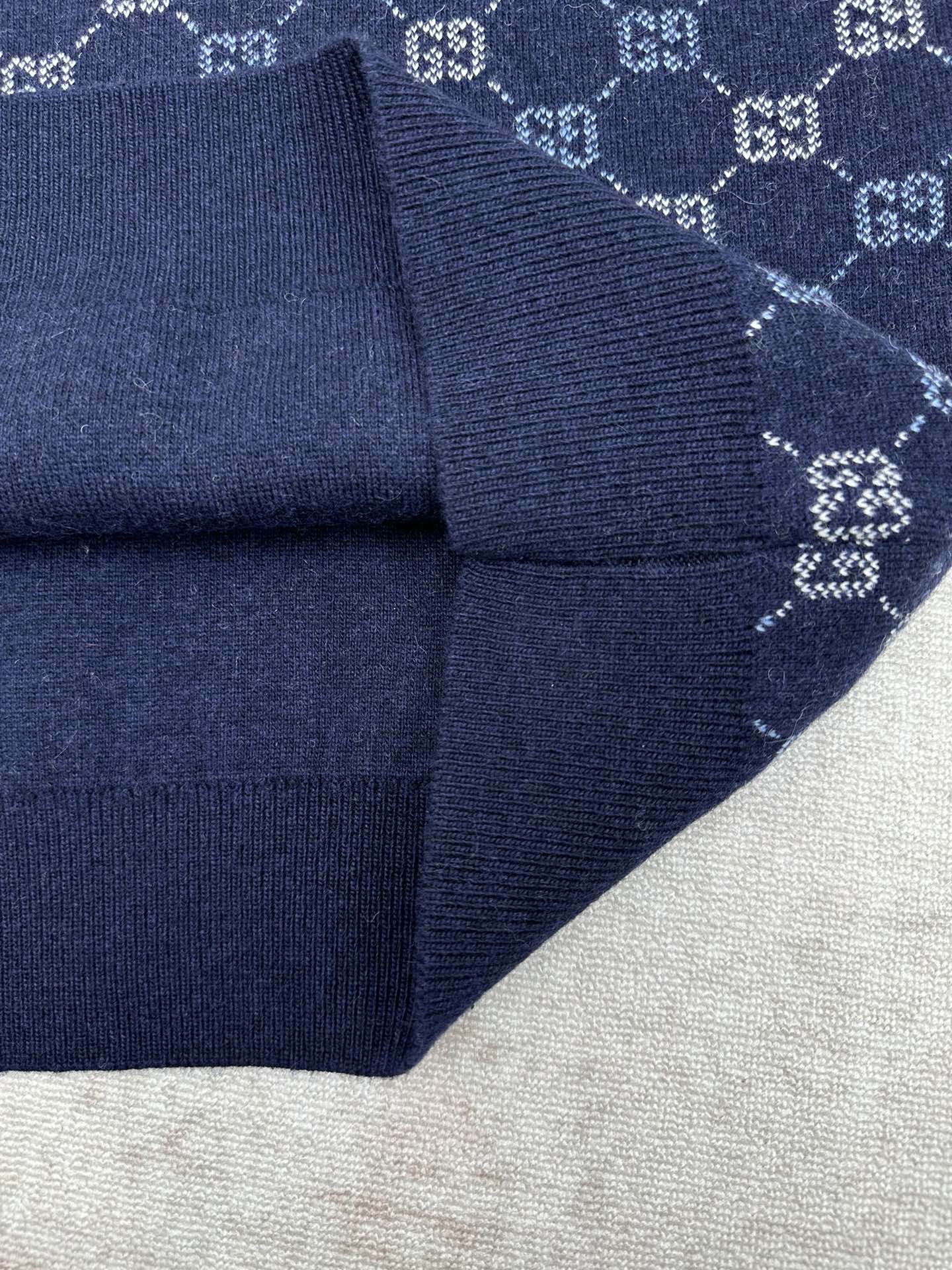 Navy knit sweater sleeve cuff with GG monogram pattern and ribbed trim