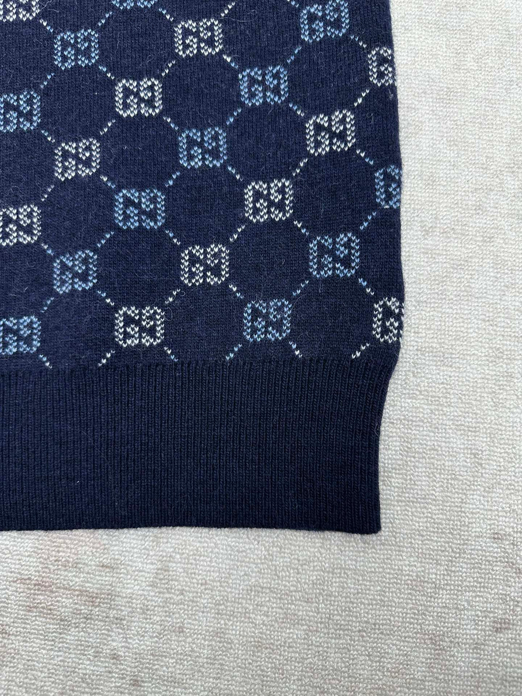 Navy knit sweater cuff with GG monogram pattern and solid ribbed hem