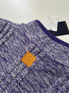 Knit sweater chest close-up with stitched logo patch and heathered blue pattern