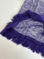 Knit sweater detail with layered purple fringe and heathered blue stitch texture