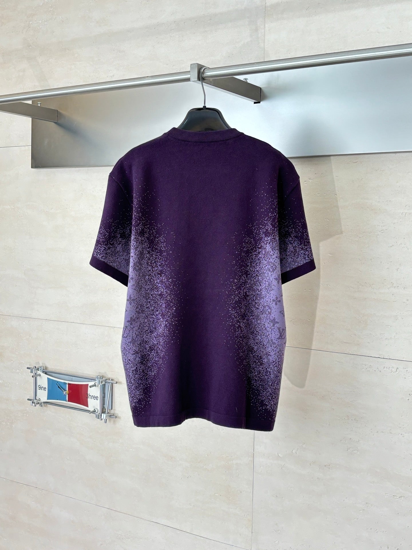 Purple patterned T-shirt, back view, on hanger