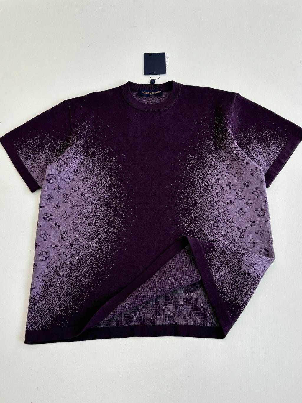 Purple T-shirt with monogram-style allover print, laid flat